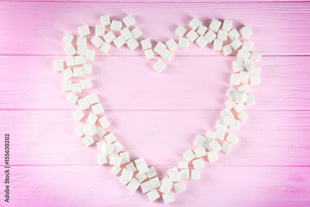 Sugar cubes in heart shape on wooden table