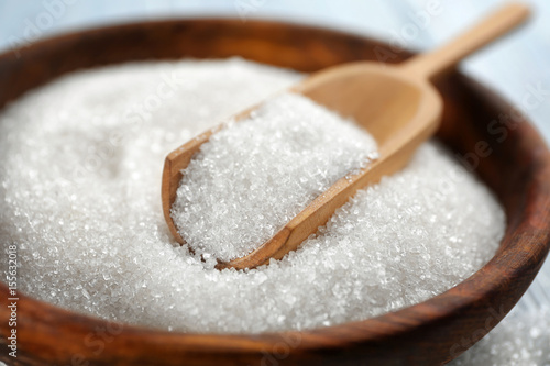 Bowl and scoop with sugar, closeup