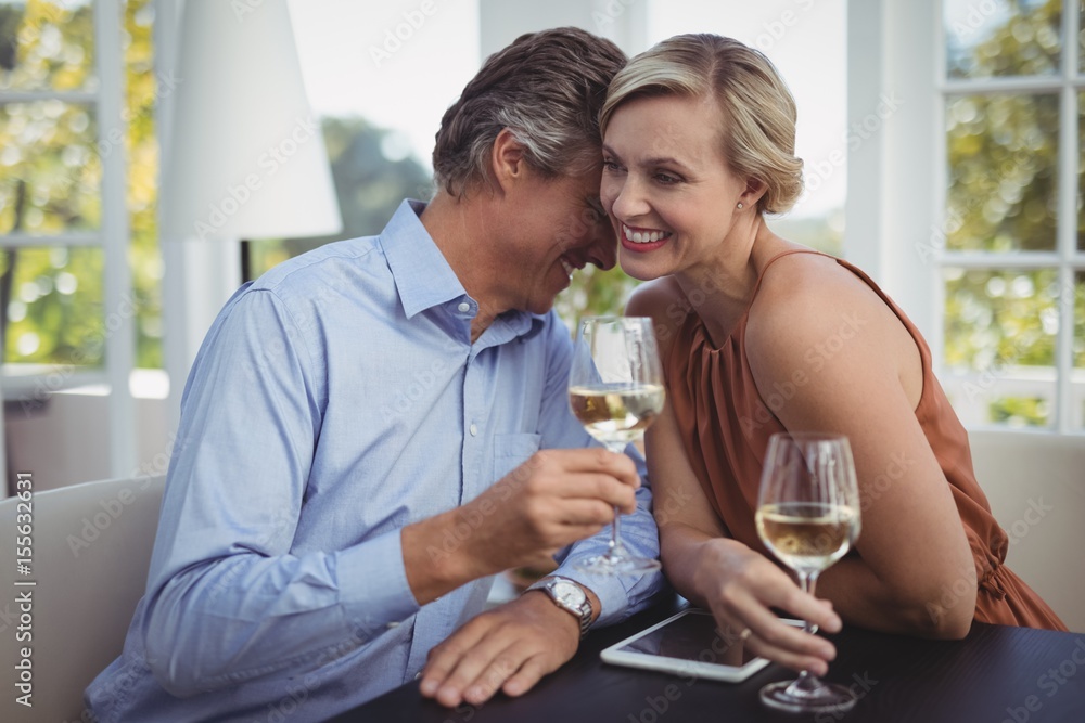 Couple interacting while having wine in restaurant