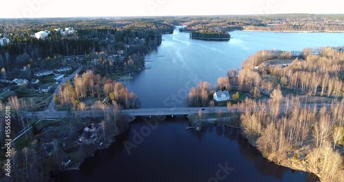 Hiidensalmi, Cinema 4k aerial view of cars driving on routio hiidensalmi bridge at a sunset above lohjanjärvi, in Lohja, Finland photo