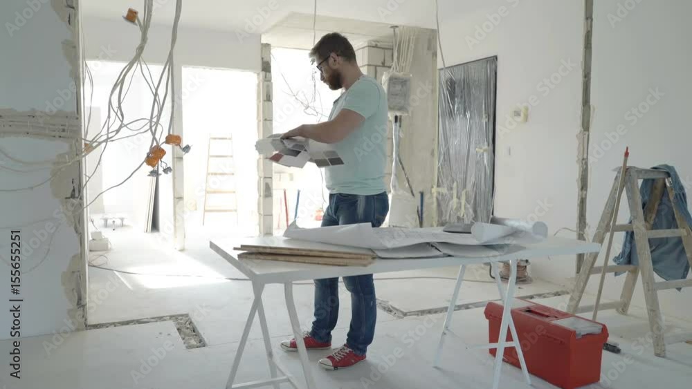 Young man choosing paint from palette for wall at his new home
Young man choosing paint from palette for wall at his new home