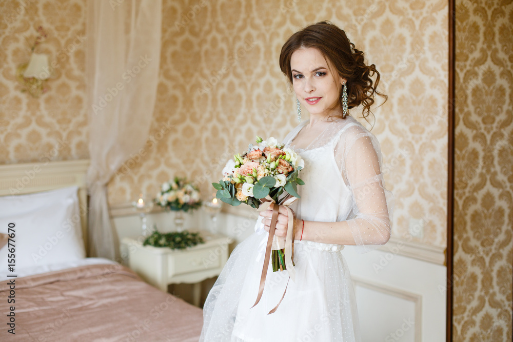 Pretty young Bride. Boudoir morning of the bride. Looking on her bouquet Pretty young Bride. Boudoir morning of the bride. Looking on her bouquet