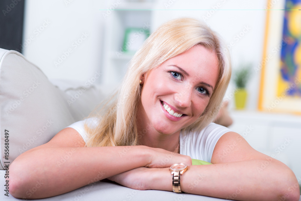 frau blond lächelt und liegt auf couch frau blond lächelt und liegt auf couch