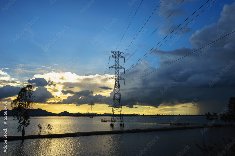 Sunset lake scene with electric poles and wires in south of Vietnam