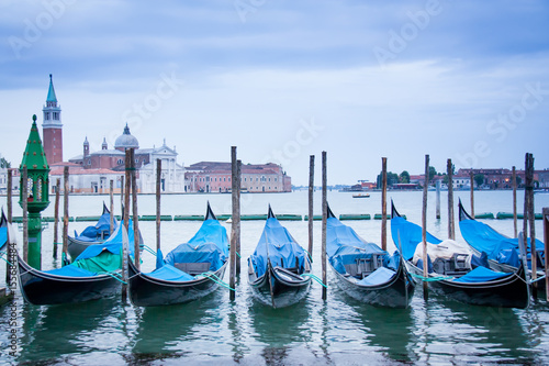 Gondolas floating on the water with Venice in the background.