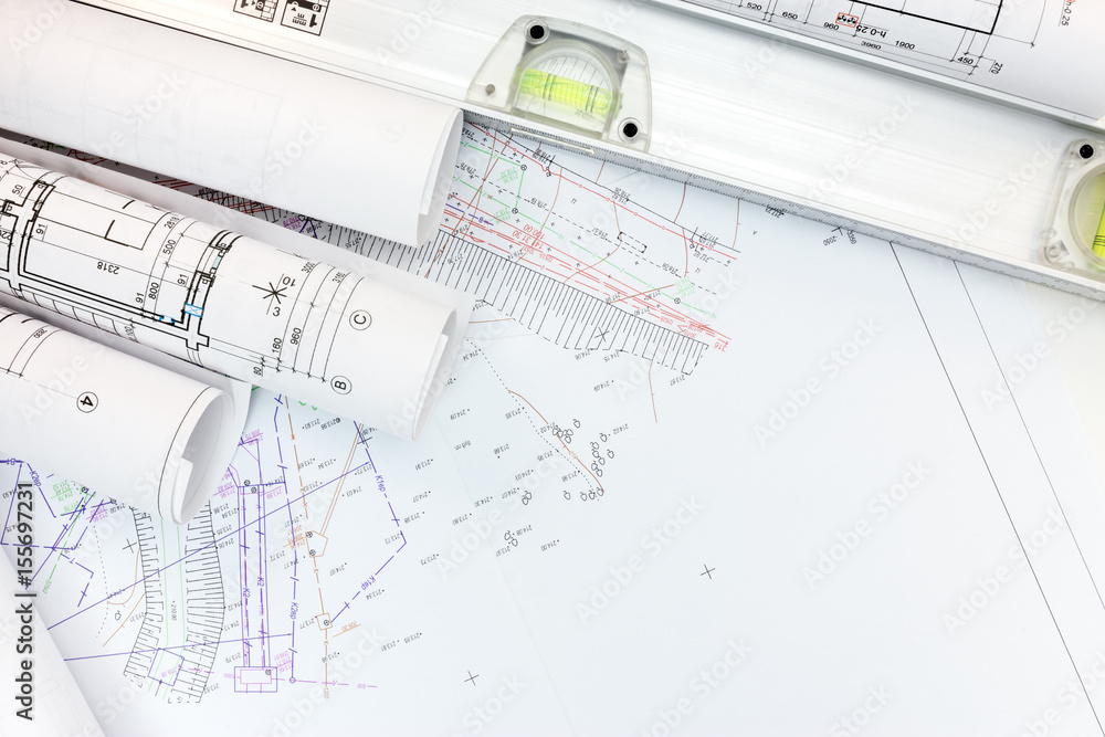 architect workplace with rolled plans, housing schemes and spirit level. top view architect workplace with rolled plans, housing schemes and spirit level. top view