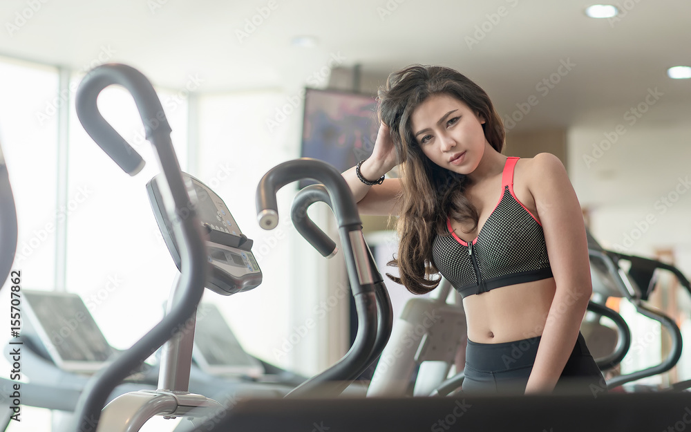 Beautiful young lady rest on the trainer in a gym. Beautiful young lady rest on the trainer in a gym.