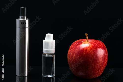 Aroma of a red apple for an electronic cigarette on a black background photo