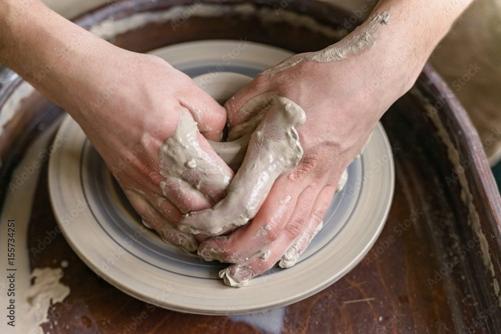 Hands working on pottery wheel Hands working on pottery wheel
