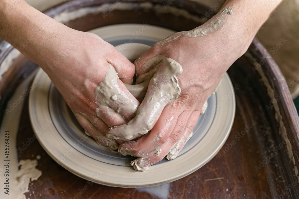 Hands working on pottery wheel