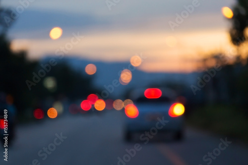 night light of traffic car in the urban street with beautiful twilight sunset sky, abstract blur