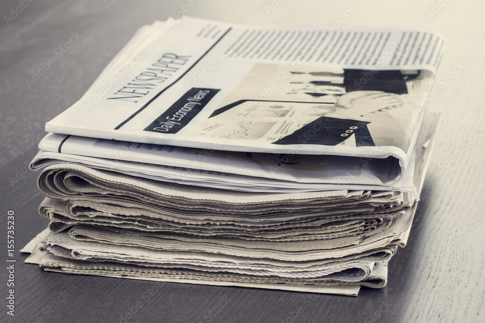 Stack of newspaper on wooden table Stack of newspaper on wooden table