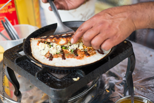 Dosa Being Rolled on a Hot Skillet on Stove