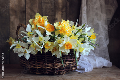Fototapeta Naklejka Na Ścianę i Meble -  Yellow daffodils in a basket on the table.