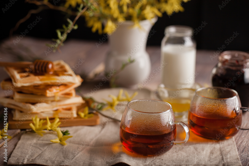 Waffles, tea, honey and milk on a neutral background Waffles, tea, honey and milk on a neutral background