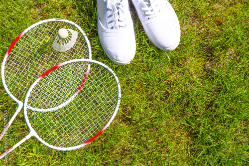 Badminton rackets and shuttlecock against a background of green grass. Concept of a healthy sport lifestyle