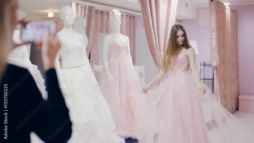 Pretty girl trying on prom gown in fitting room Pretty girl trying on prom gown in fitting room