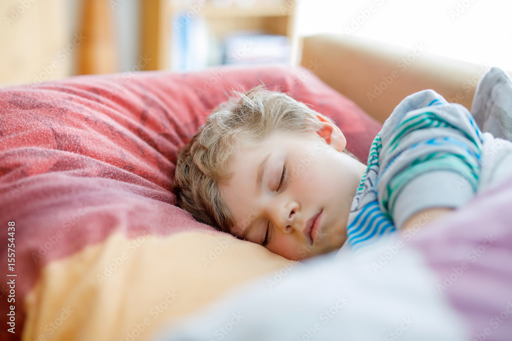Little sad preschool kid boy sleeping. Tired schoolchild resting after school classes. Little sad preschool kid boy sleeping. Tired schoolchild resting after school classes.