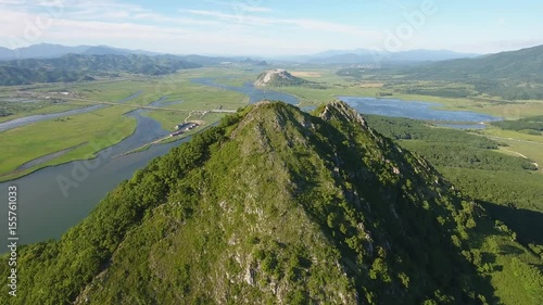 High rock top Sestra Sister hill Nakhodka Primorsky Krai Russia. Aerial drone forward flight 4k. Beautiful Russian nature blue long river. Japan sea summer spring sunny day.  photo