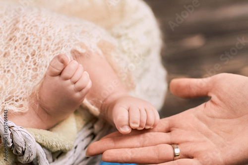 Female hand and baby feet. Close up of childish legs. Maternal bonding theory.