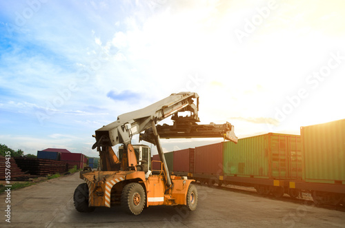 stacker and container train freight for import export concept in sunset background