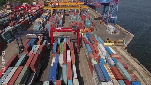 Commercial port zone of Vladivostok Russia  Primorsky Krai local industrial shipping containers cranes transport. Golden bridge unloading Freight city panorama. Summer. Aerial flight forward photo