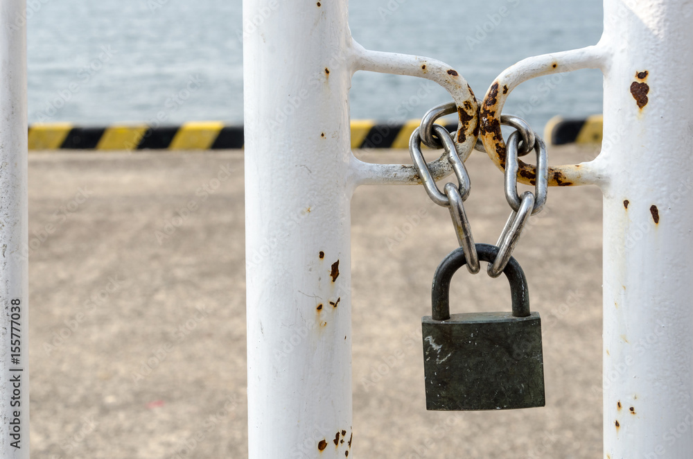 Key locked on chain front of the sea, meaning security, no entry, no freedom