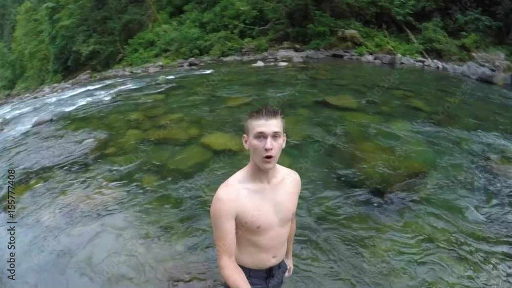 Man Holds A Gopro Stick And Falls Backwards With A Big Splash In River, Completely Submerges Underwater, Then Emerges 