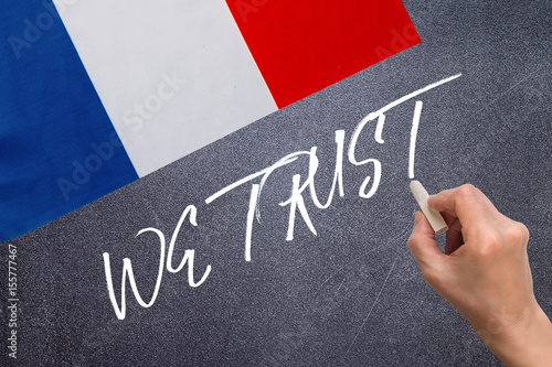 WE TRUST on the chalk board and the flag of France