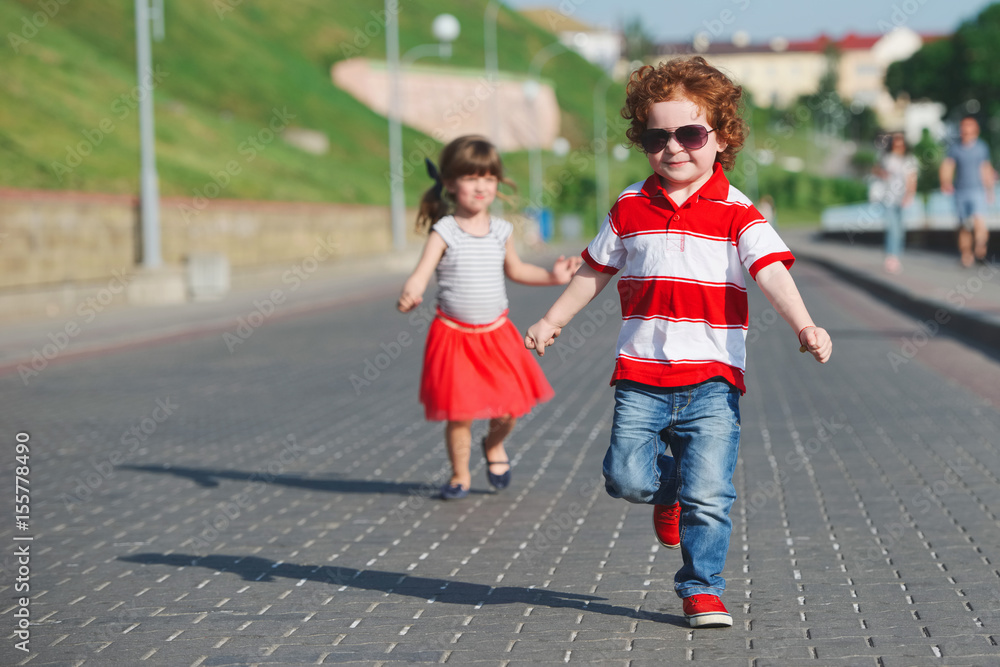 two happy children running on the promenade
