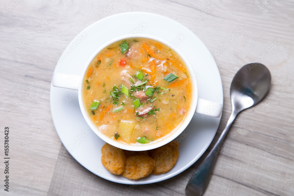 Peas soup with meat, smoked sausage and croutons. Selective focus