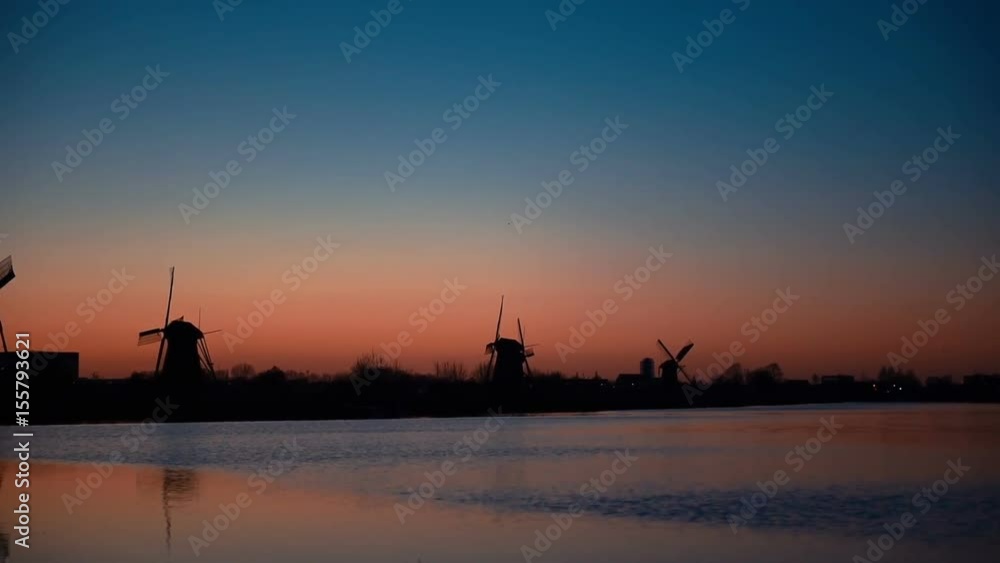 Traditional Dutch windmills from the channel Rotterdam at sunset. Water mirror effect. Holland. Traditional Dutch windmills from the channel Rotterdam at sunset. Water mirror effect. Holland.