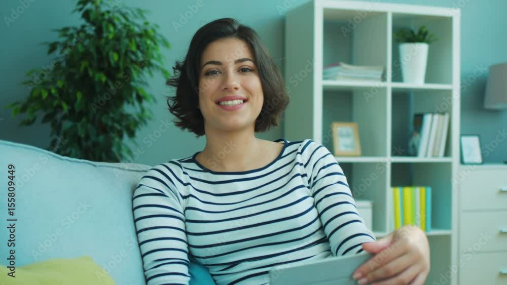 Attractive woman sitting on the couch smiling and looking straight at the camera. Portrait shot Attractive woman sitting on the couch smiling and looking straight at the camera. Portrait shot