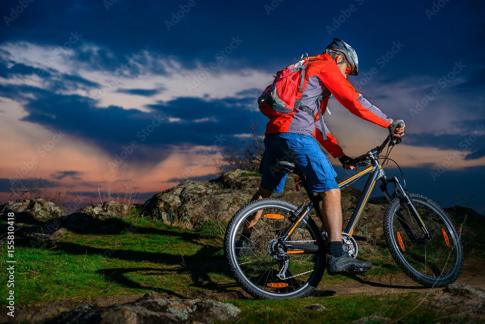 Fototapeta premium Cyclist Riding Mountain Bike on Spring Rocky Trail at Beautiful Sunset. Extreme Sports and Adventure Concept.