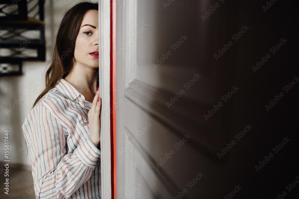 Portrait of a beautiful girl on the background of a large wooden door.