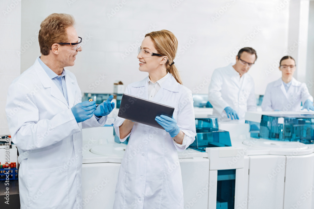 Positive delighted female scientist holding tablet Positive delighted female scientist holding tablet