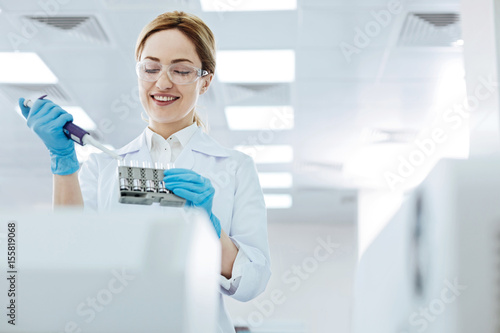 Positive delighted female scientist doing experiment