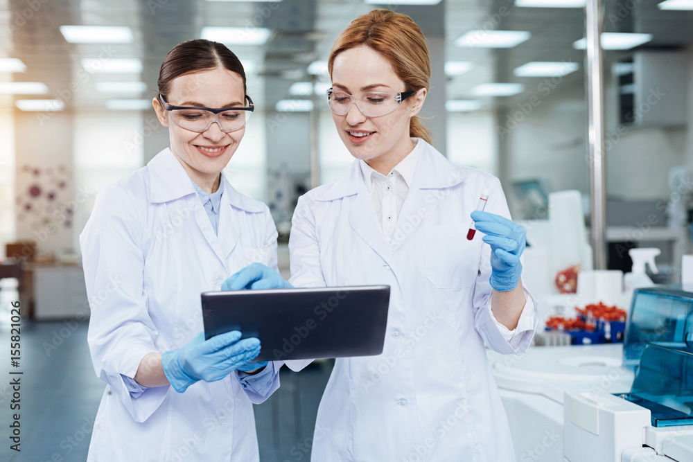 Two colleagues looking at screen of the tablet