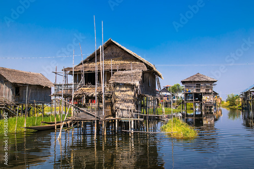 Ancient houses and their reflection in the water on the Inle Lake, Myanmar.