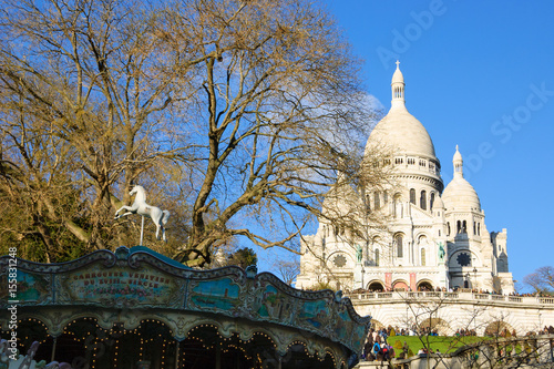View of Sacre Coeur Basilica and an old carousel at foreground (Paris, France). 