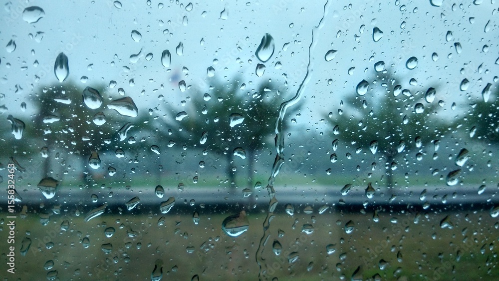 rain drops on window with tree blur background. photo. rain drops on window with tree blur background. photo.