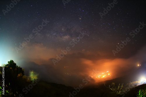 Milky way galaxy with cloud and city light at Phutabberk Phetchabun in Thailand.Long exposure photograph.With grain photo