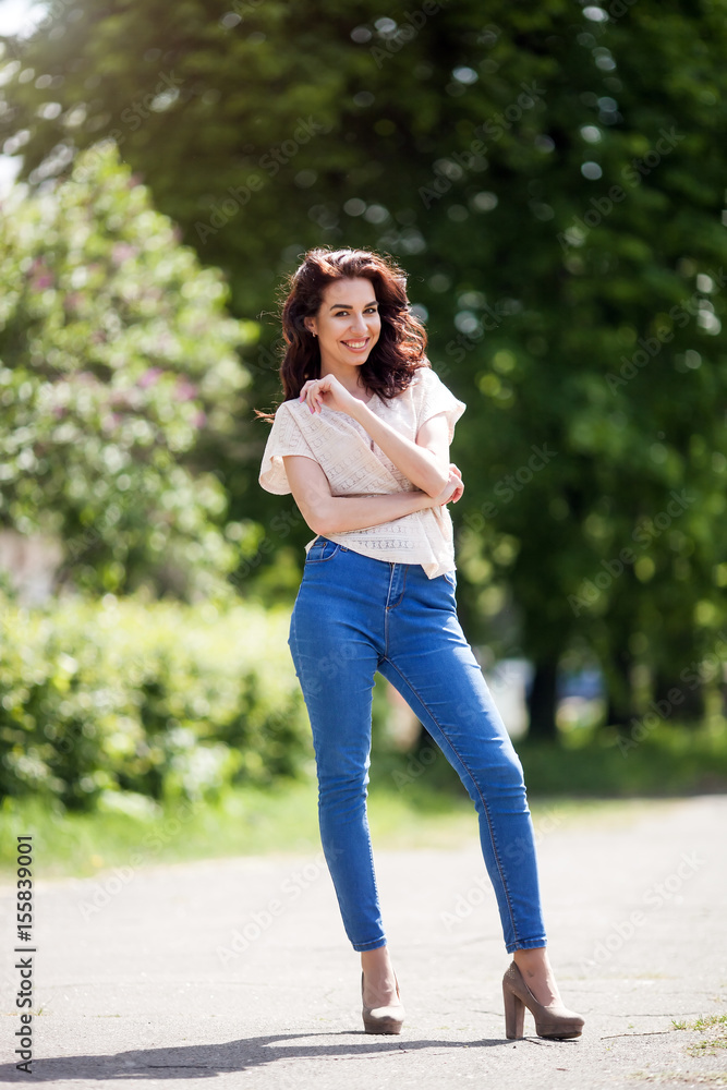 Outdoor portrait of a young beautiful happy smiling woman walking outdoor. Model looking at camera. Lady wearing stylish clothes. Outdoor portrait of a young beautiful happy smiling woman walking outdoor. Model looking at camera. Lady wearing stylish clothes.
