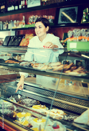 Female assistant helping to choose dessert