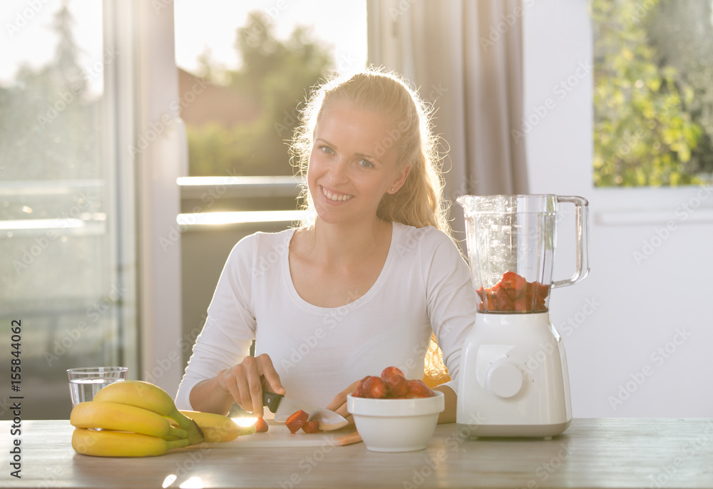 Woman preparing smoothie in blender Woman preparing smoothie in blender