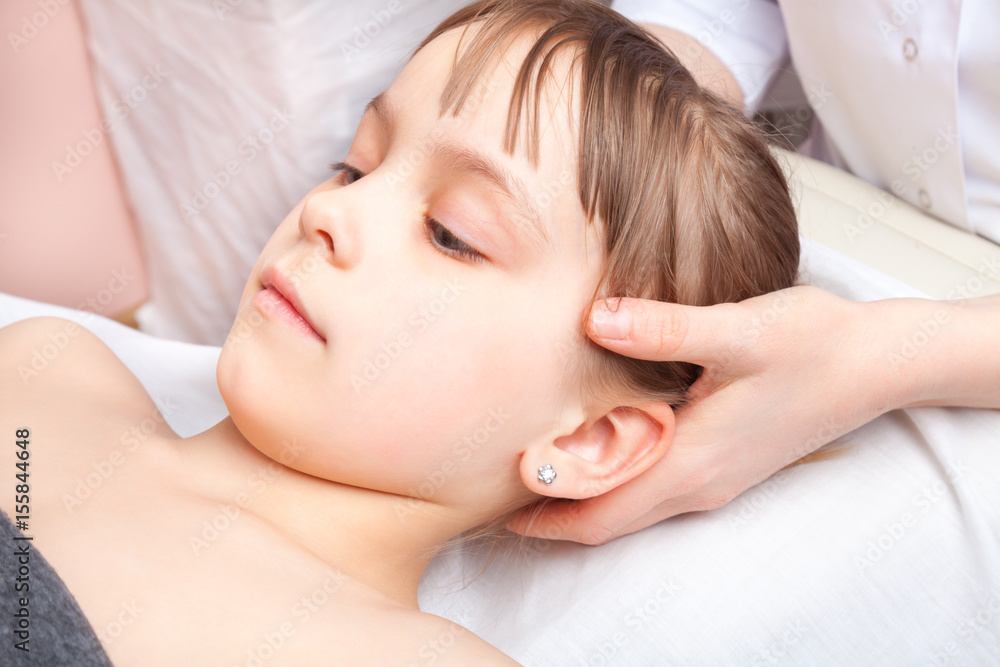 Girl receiving osteopathic treatment of her head Girl receiving osteopathic treatment of her head