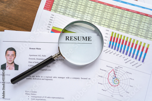 Resume, pen, magnifier, laptop on your desktop. job search 