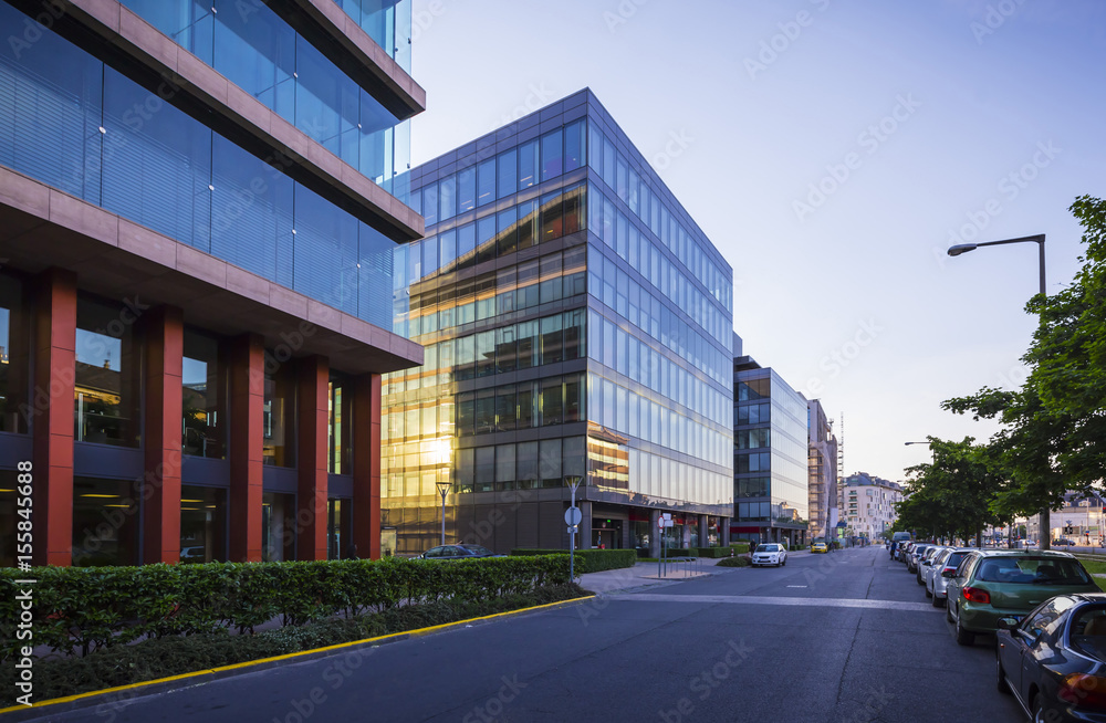Street in Budapest with modern office buildings, sun reflections on glass windows