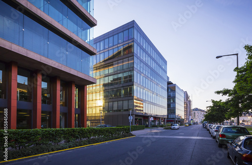 Street in Budapest with modern office buildings, sun reflections on glass windows
