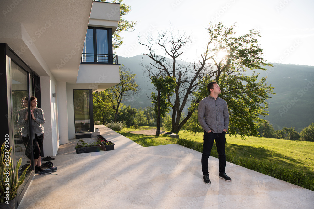 man in front of his luxury home villa man in front of his luxury home villa
